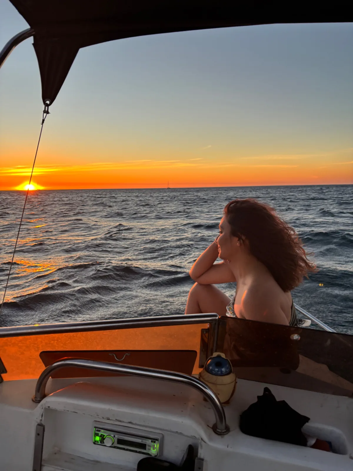 A guest relaxing on the boat, watching the sun set over the ocean
